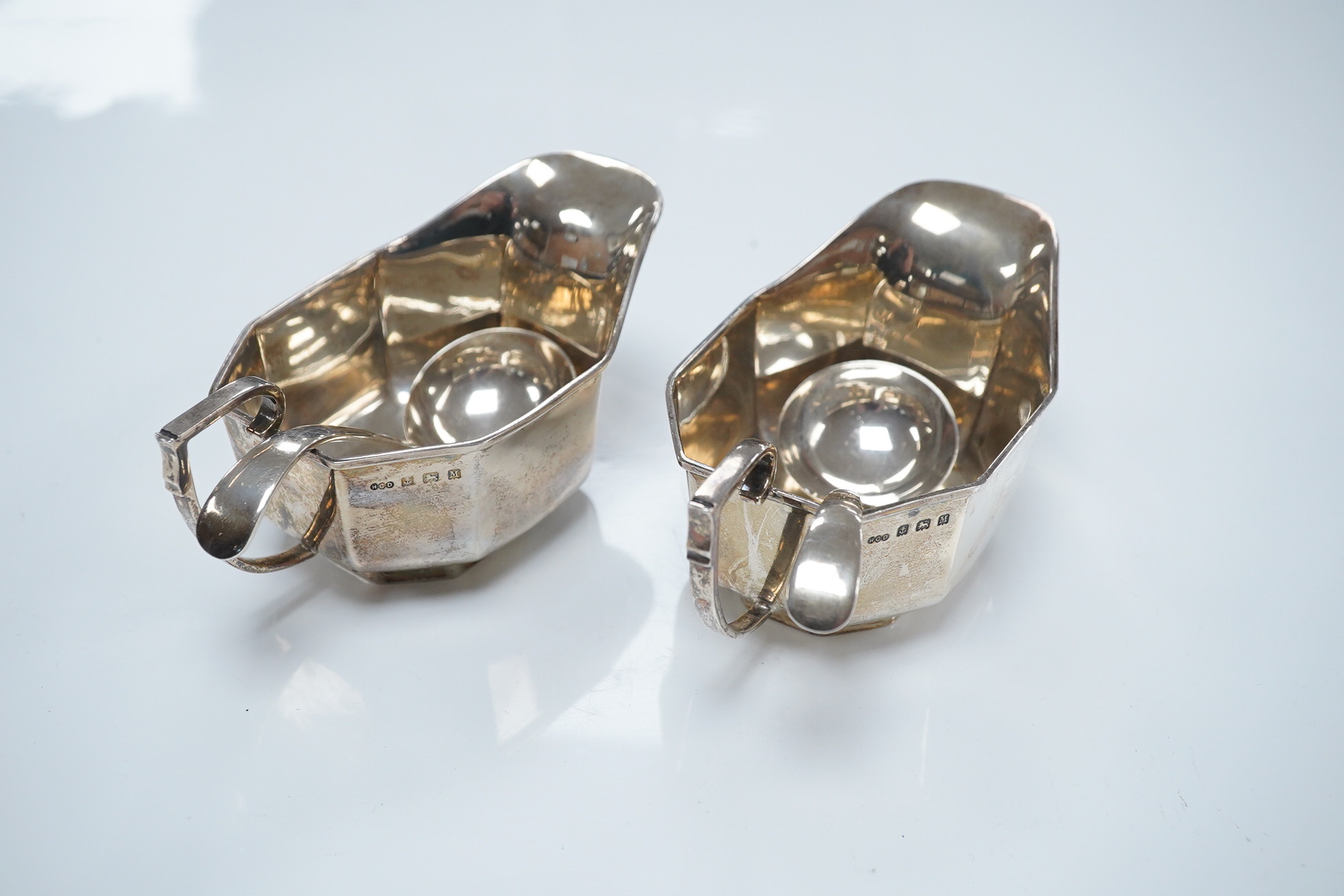 A pair of George V silver sauceboats, Henry Clifford Davies, Birmingham, 1936, length 13.4cm, together with a later pair of sauce ladles by Cooper Brothers & Sons, 9.1oz. Condition - fair to good